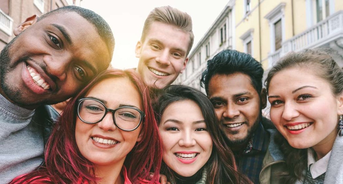 Gruppe junger Menschen lächelt in Kamera